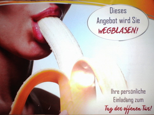 Werbung eines Fitness-Studios. Eine Frau steckt sich eine Banane in den Mund, als würde sie mit der Banane einen Fellatio machen, dazu der Text 'Dieses Angebot wird sie WEGBLASEN! Ihre persönliche Einladung zum Tag der offenen Tür!'