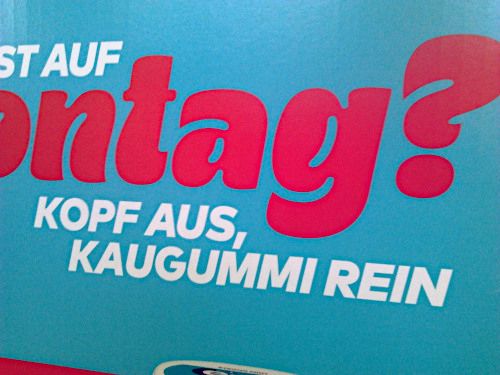 Detail aus einer in einem Supermarkt aufgestellten Printwerbung für Kaugummi: Lust auf Montag? Kopf aus, Kaugummi rein